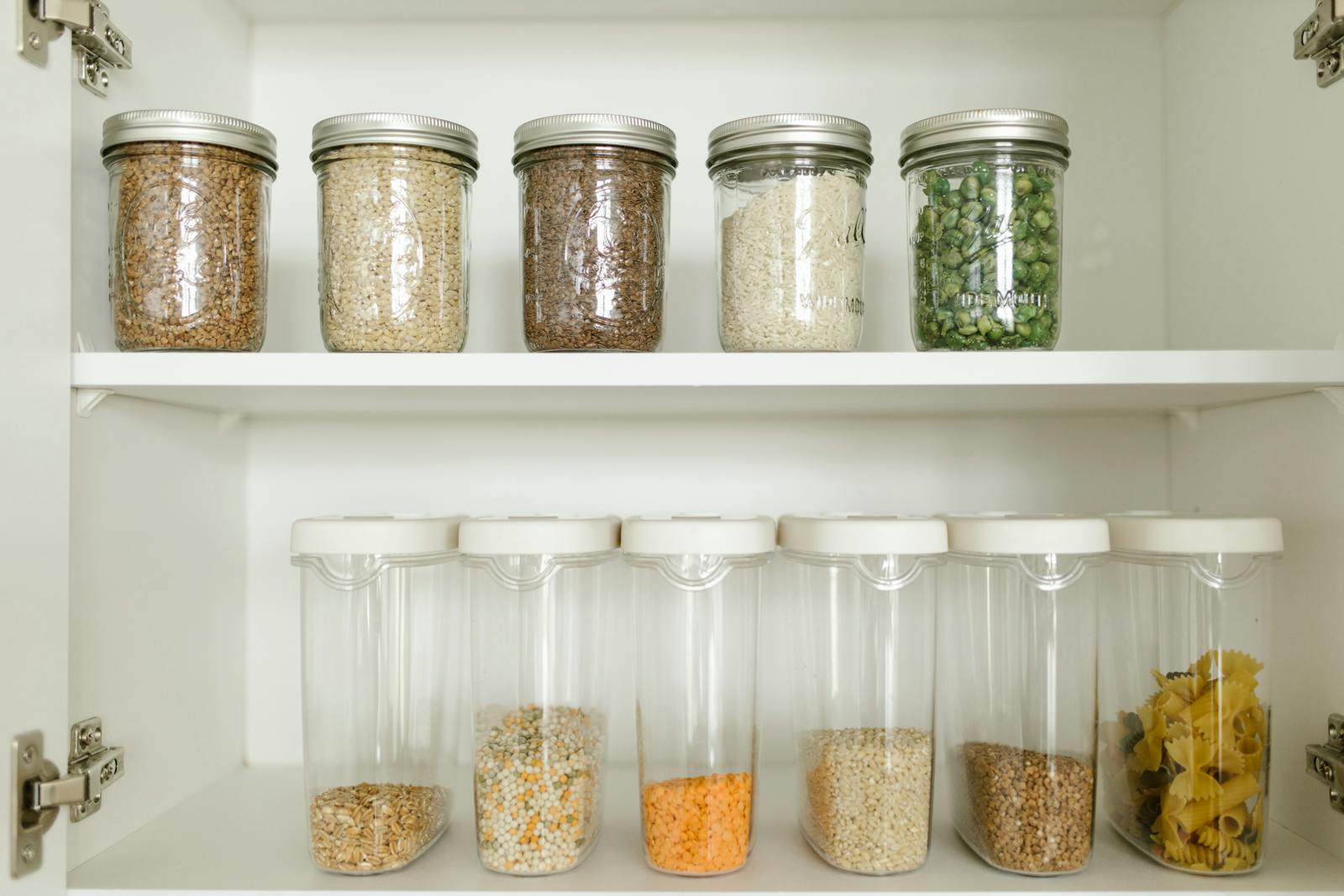 Glass jars of grains stacked on a wooden shelf