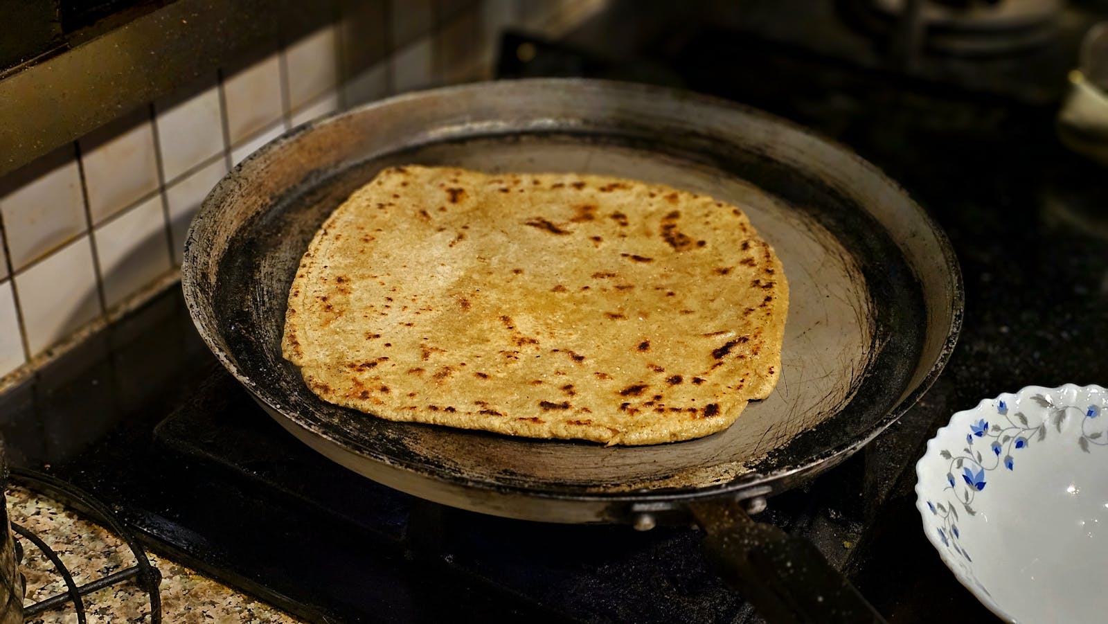 Bhakri cooking on a traditional pan